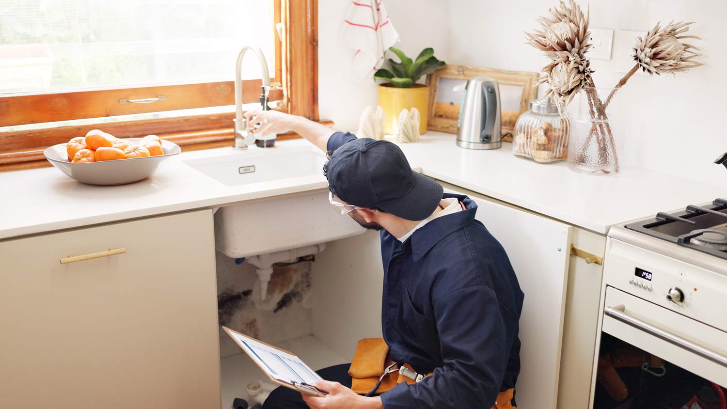handyman looking under kitchen cabinets