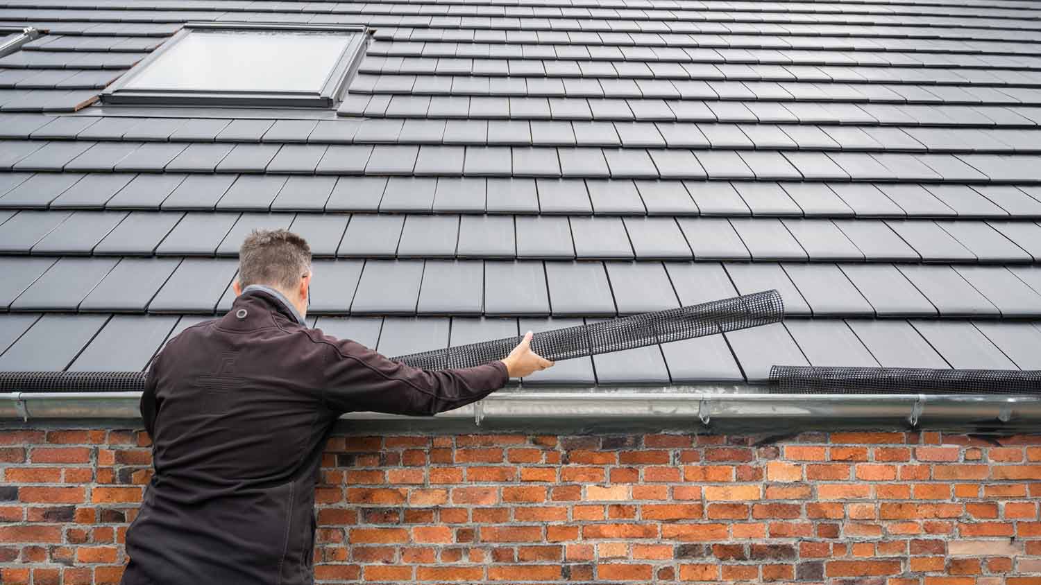 man installing mesh gutter