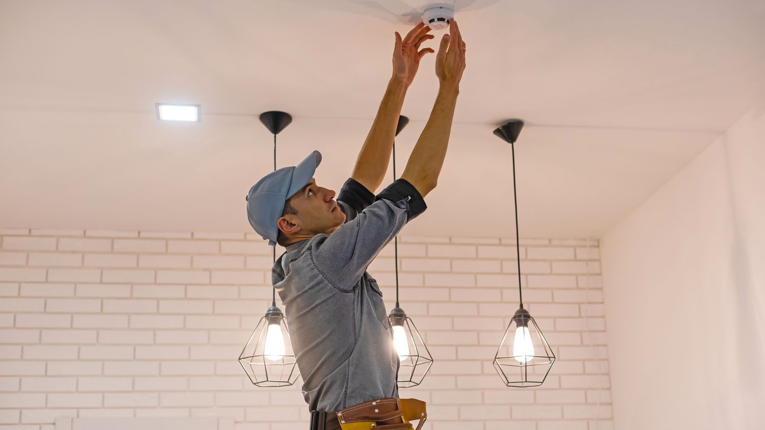 handyman installing smoke detector 