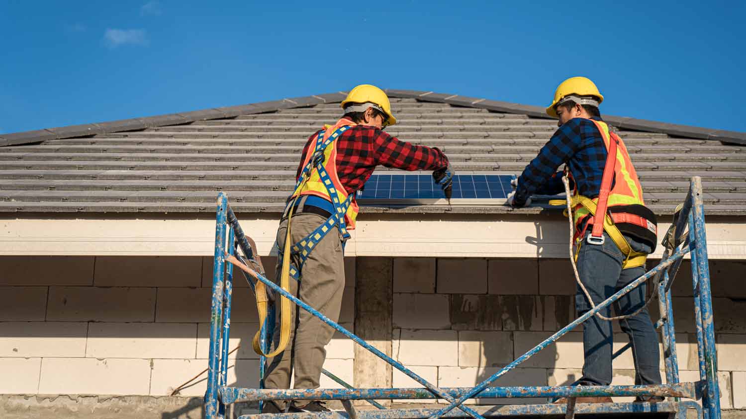 men installing solar panels on roof