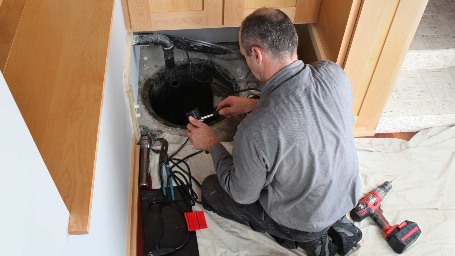 plumber installing sump pump 