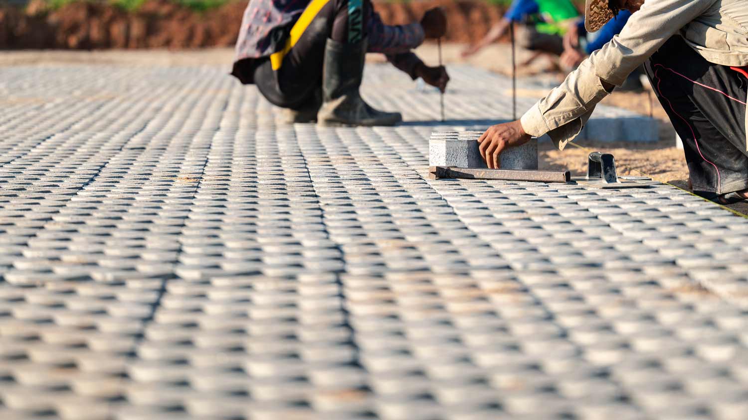 Professionals installing paver blocks 