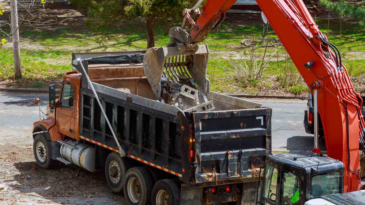 Excavator loading truck with construction waste