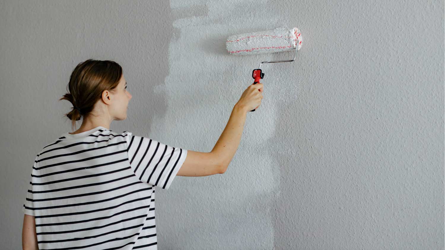 woman painting textured wall