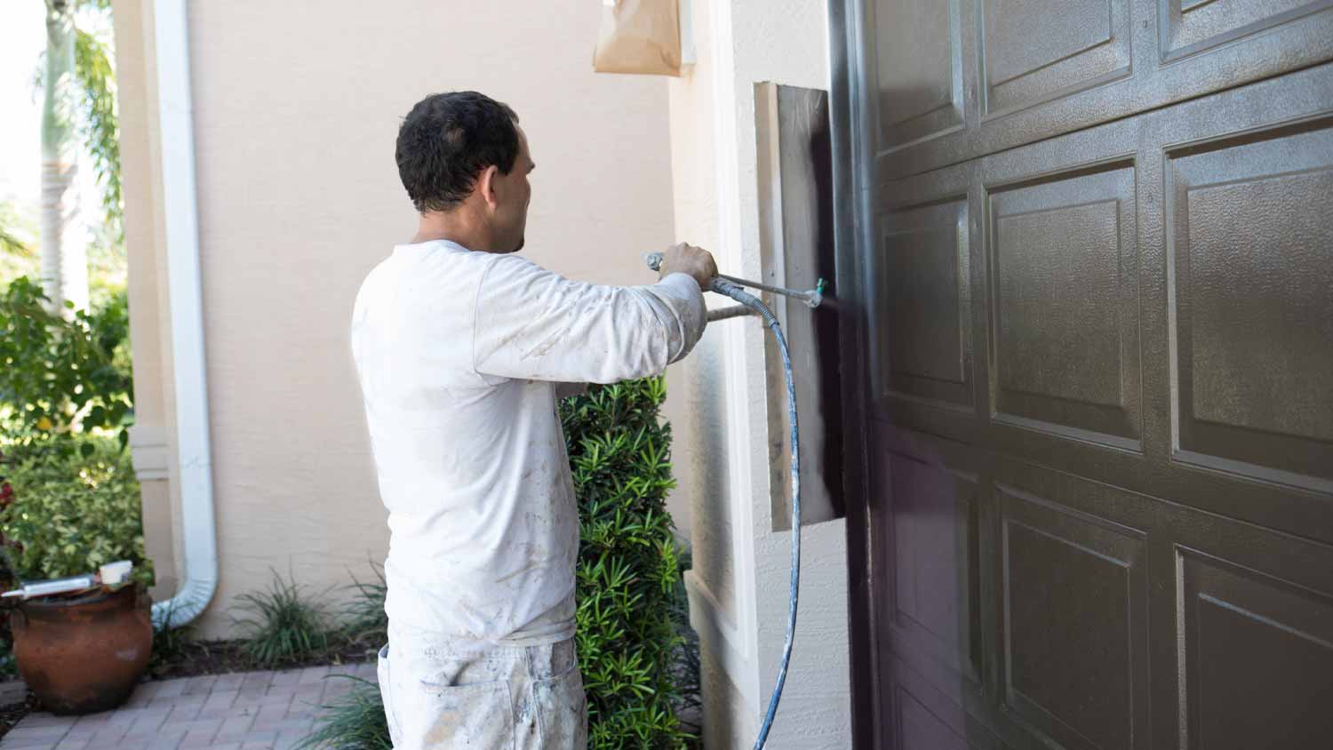 Painter painting garage door