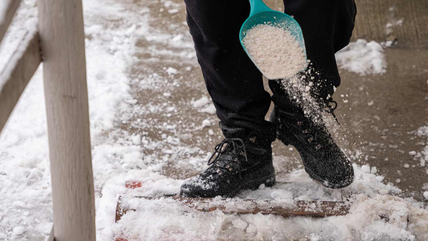 man pouring ice melt on ground