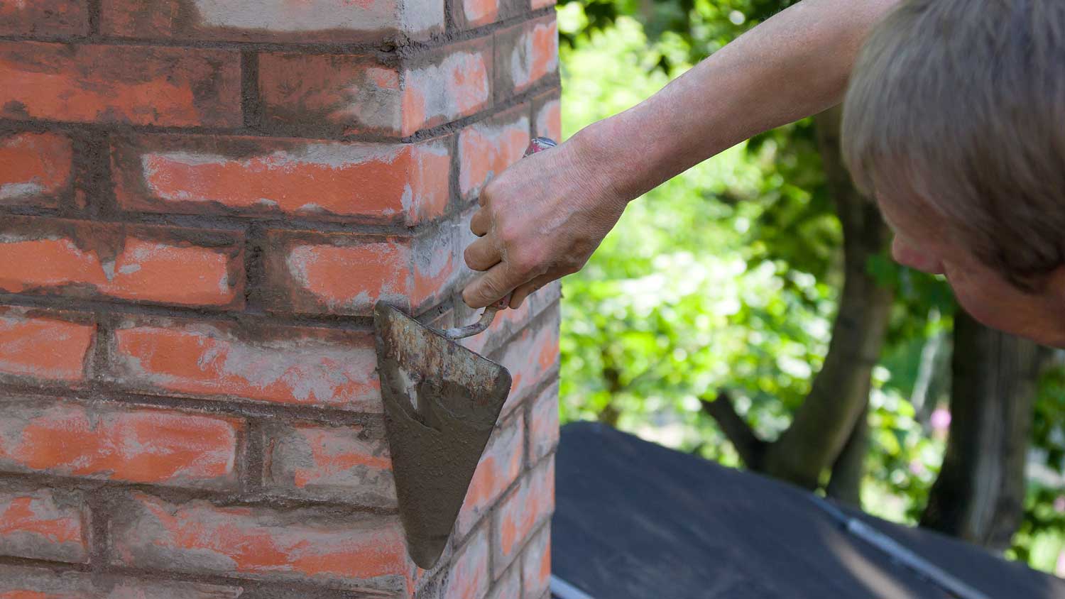 man repairing chimney joints