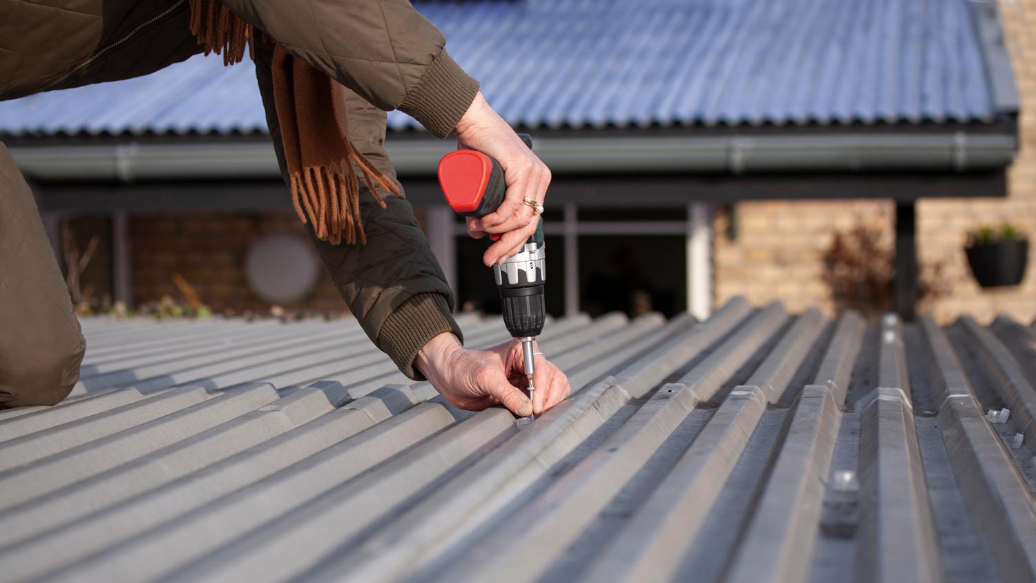 woman drilling mobile home roof 