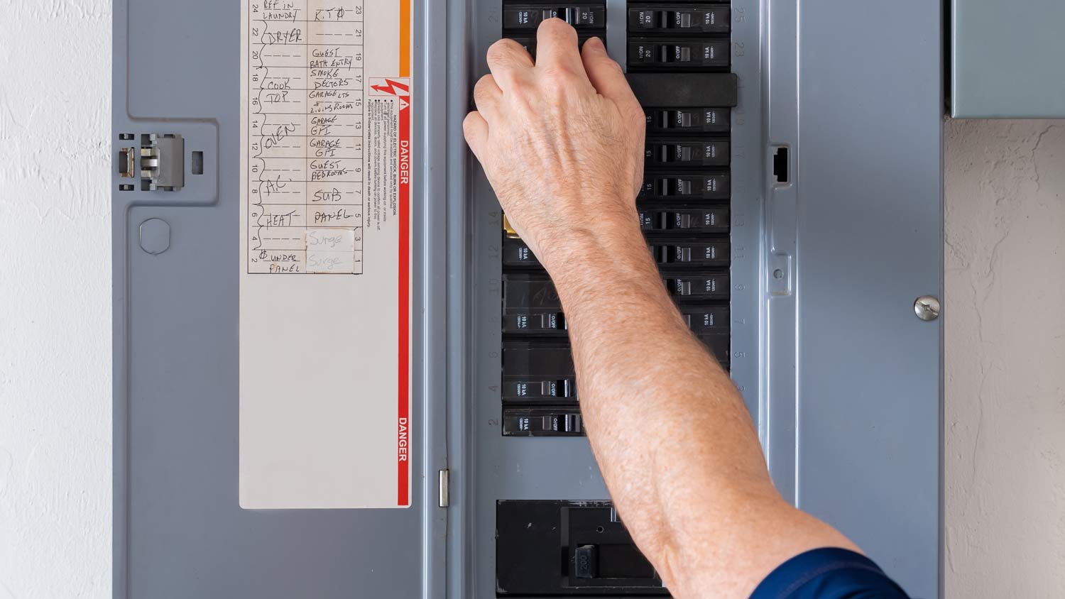 man resetting electrical panel  