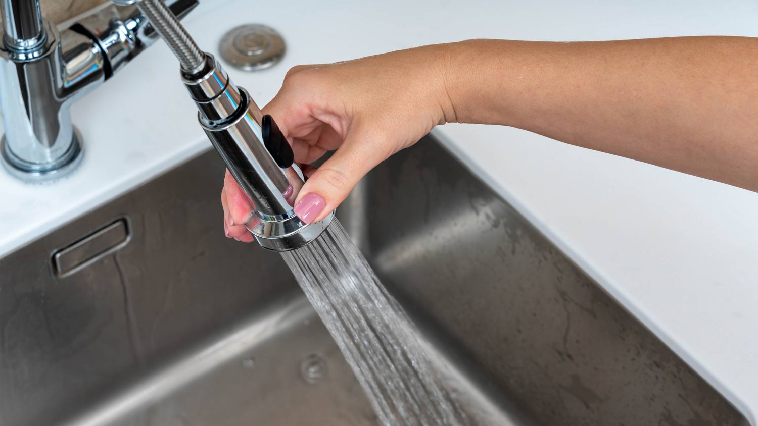 woman using faucet sprayer