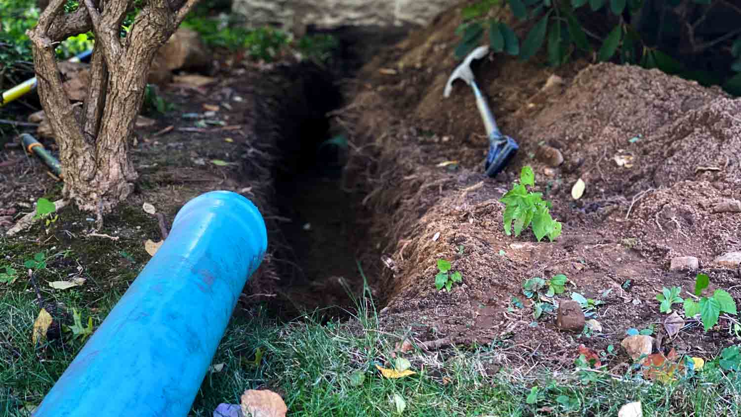 exposed drain pipe in trench 