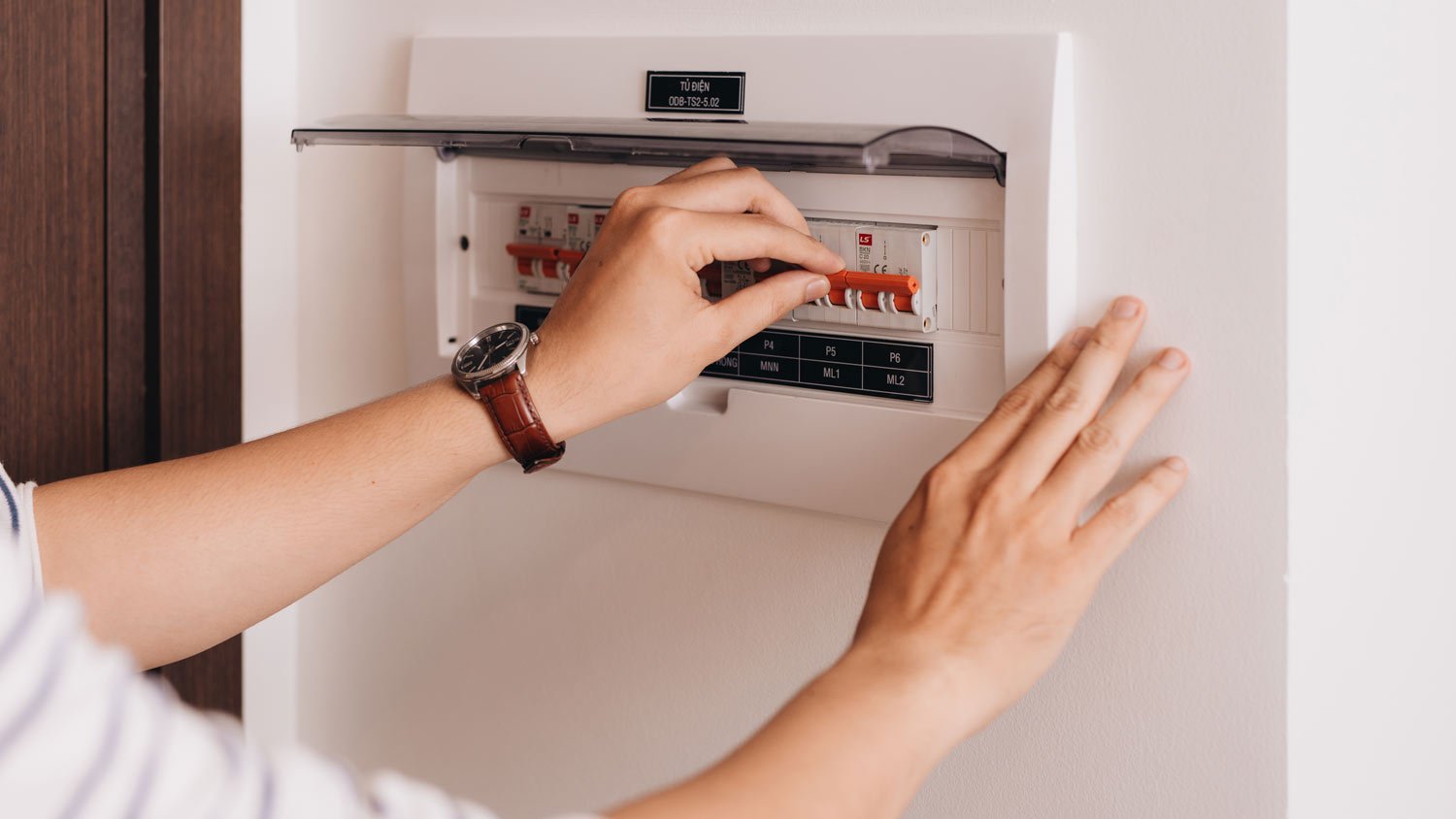 person turning circuit breaker on