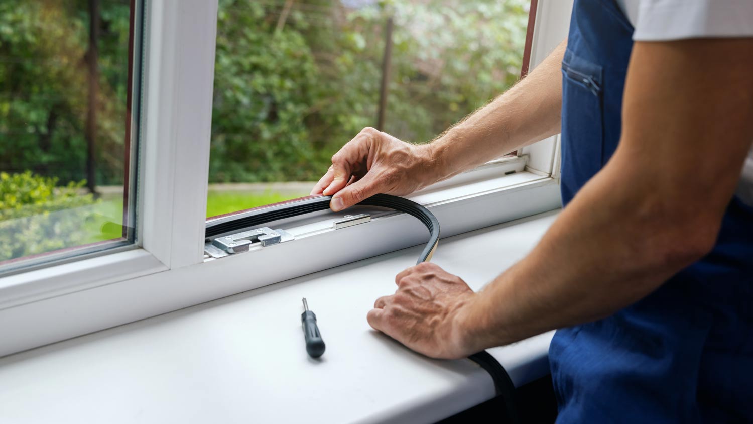 man installing weather strips on window