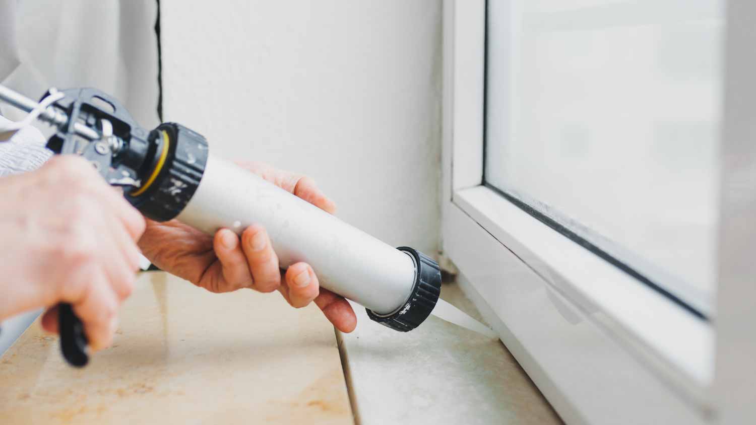 Worker using silicone gun