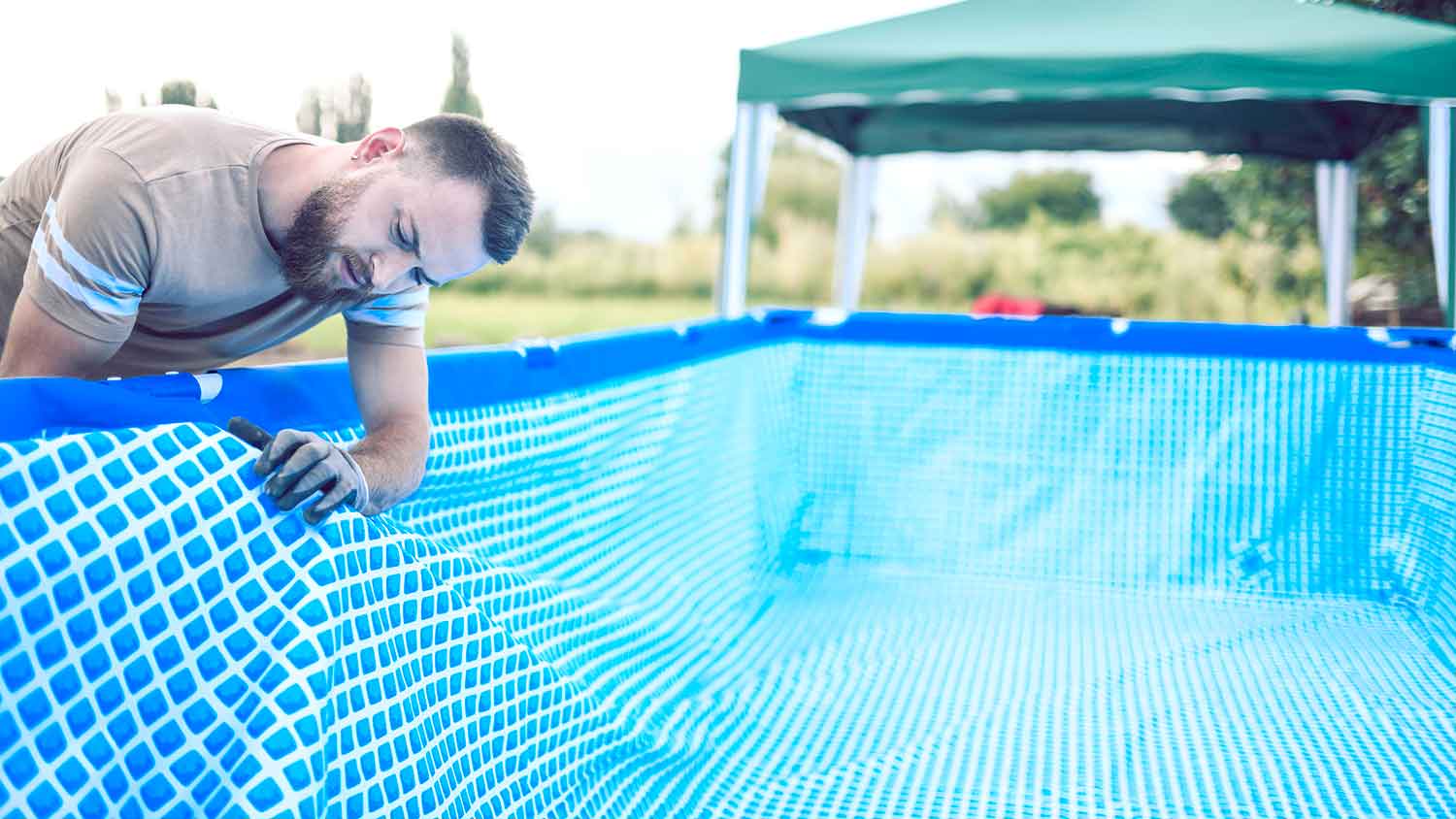 Man installing above ground pool liner