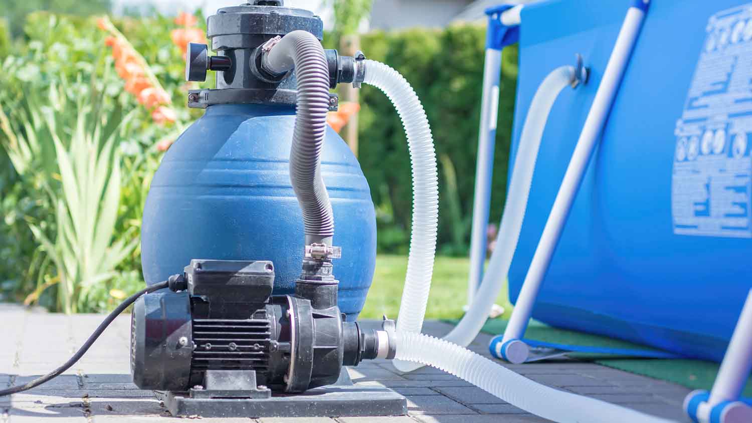 Pool pump and sand filter installed next to the pool