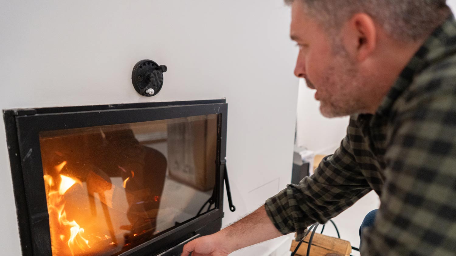 man adjusting air on fireplace