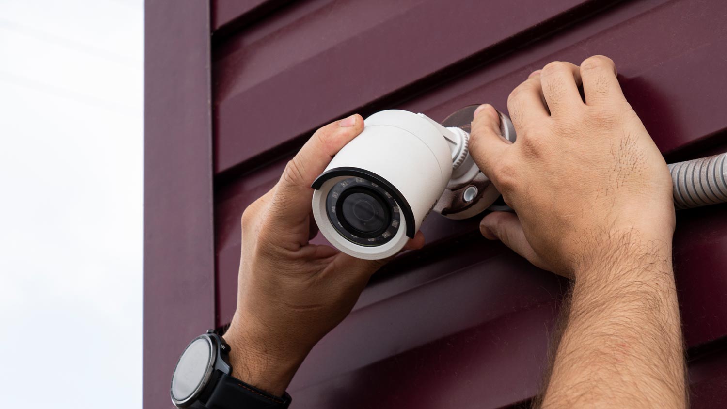 man adjusting security camera