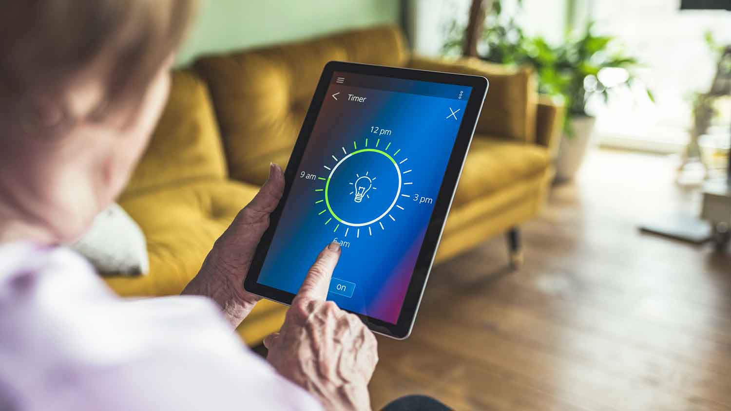 Woman using tablet to adjust smart light timer