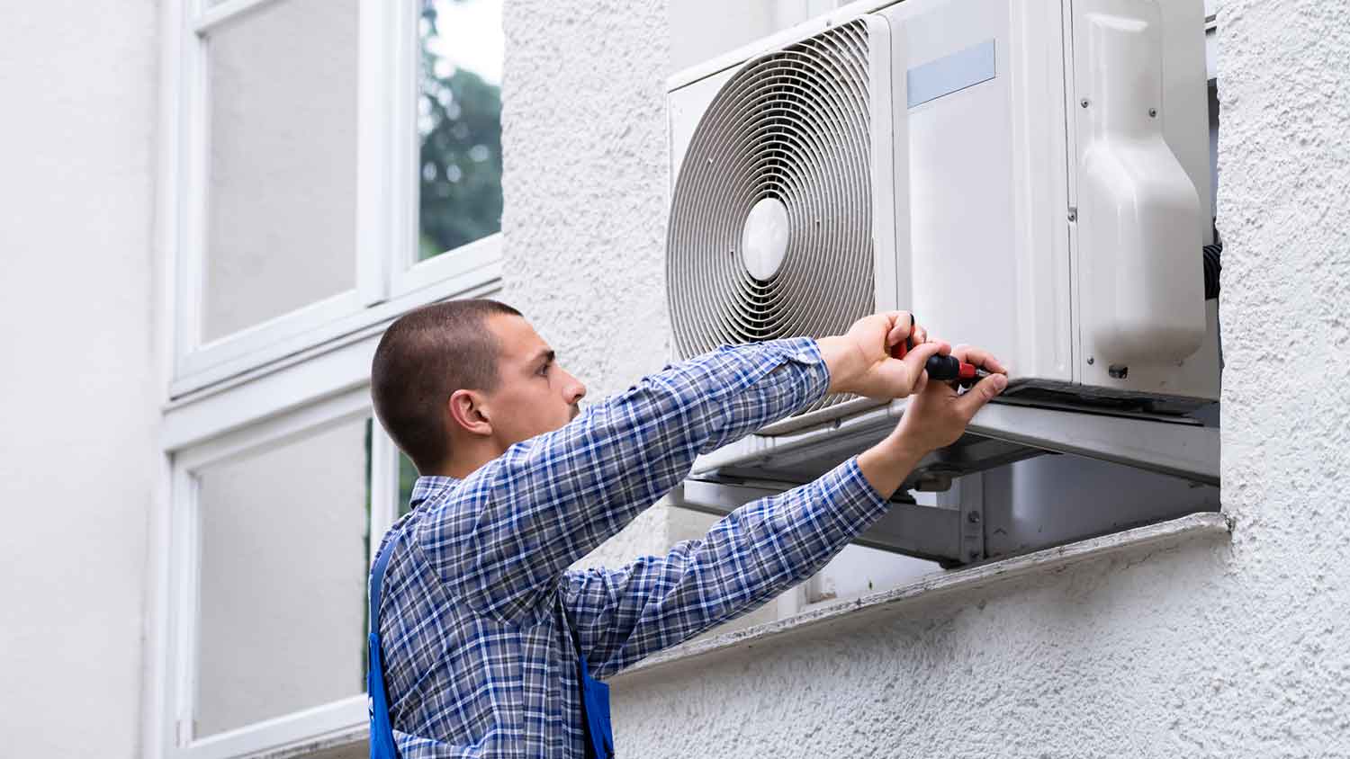 Technician repairing air conditioner unit