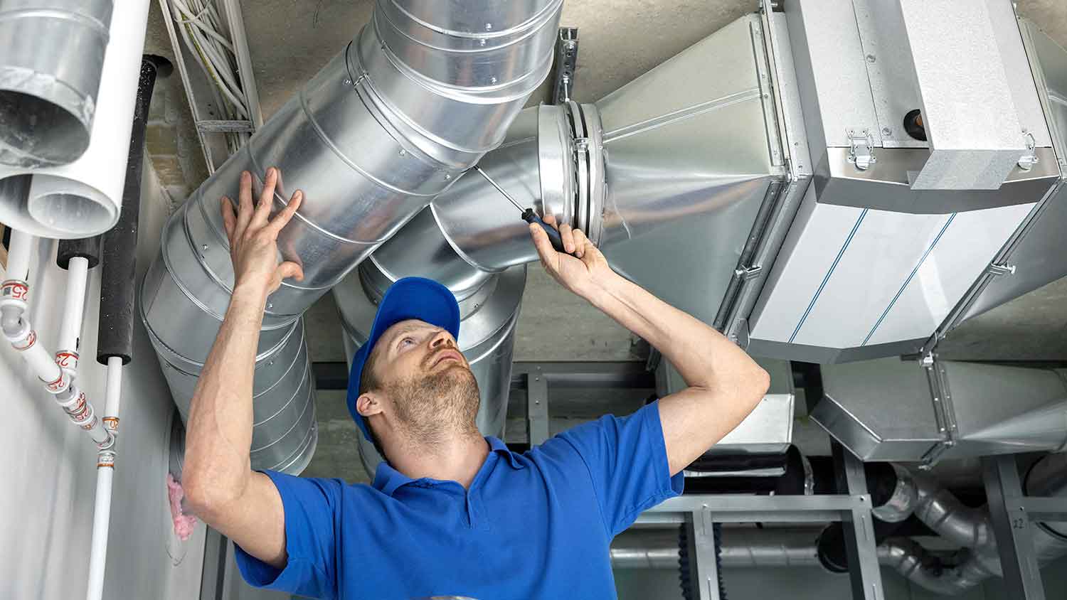 Technician repairing air duct pipes in the house