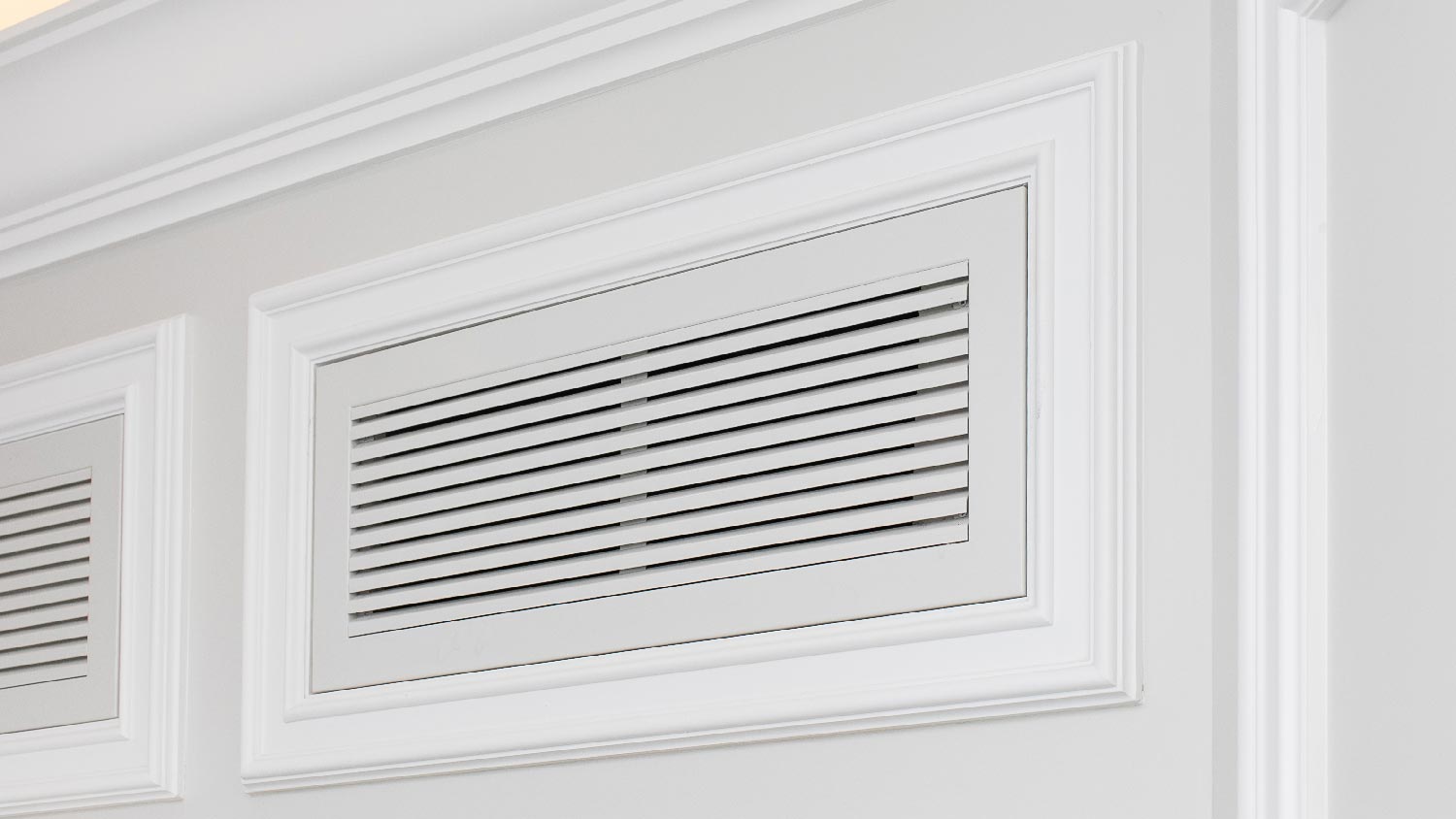 An air vent with classic white moldings