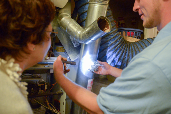 Worker and homeowner checking ducts