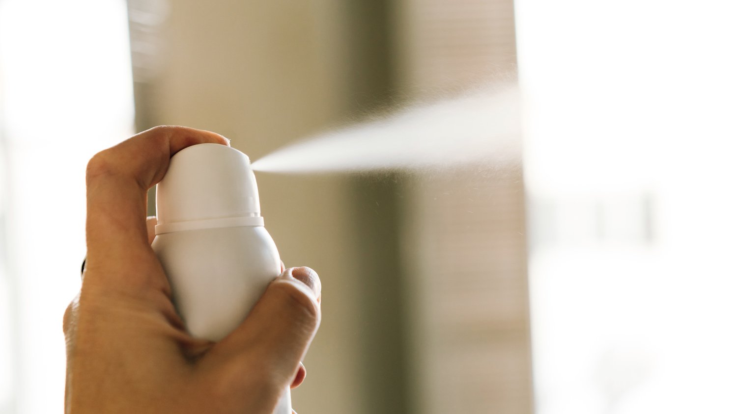 A bottle of room spray in a woman's hand