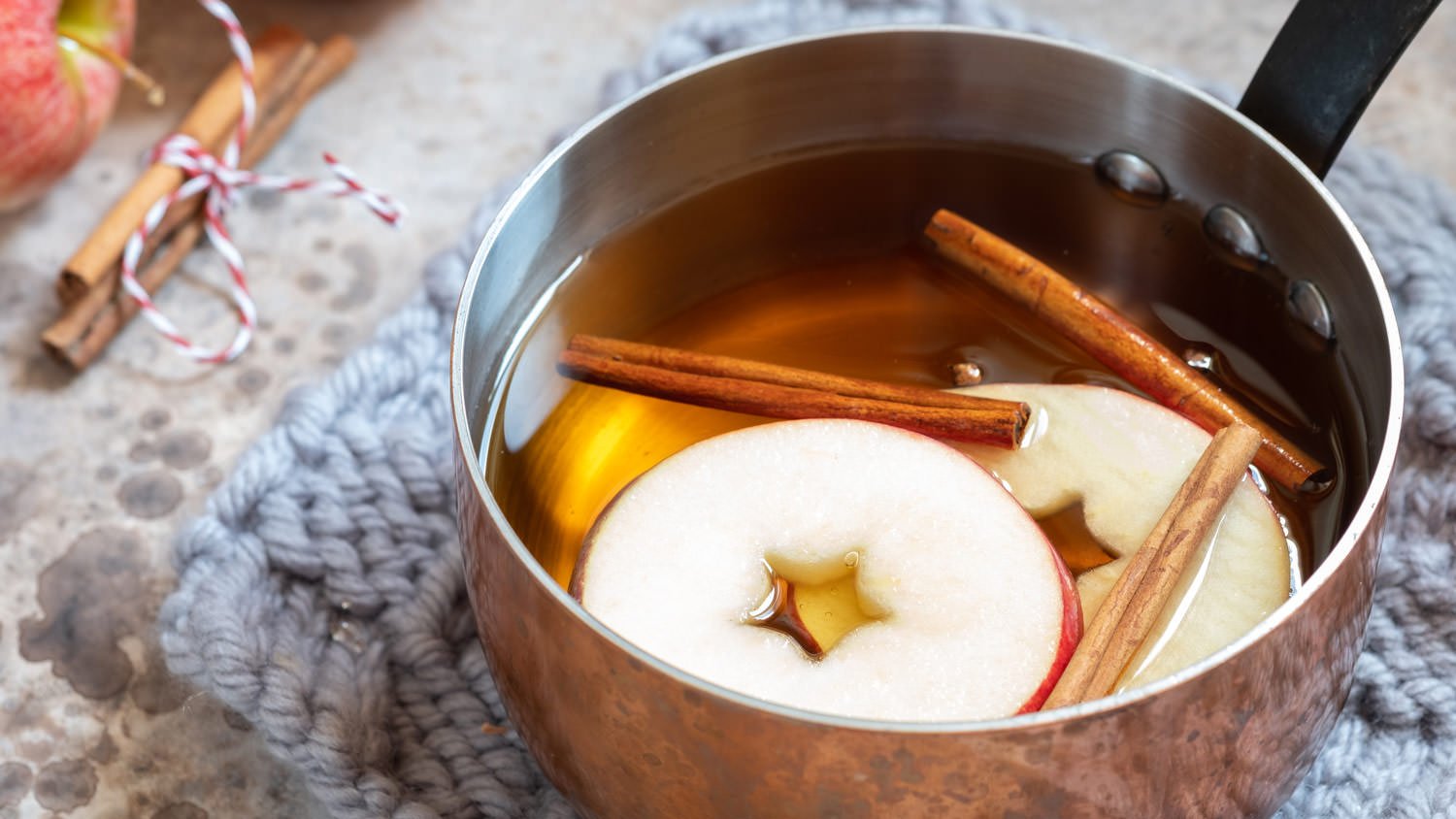 Apple, cinnamon sticks and star anise inside a pot