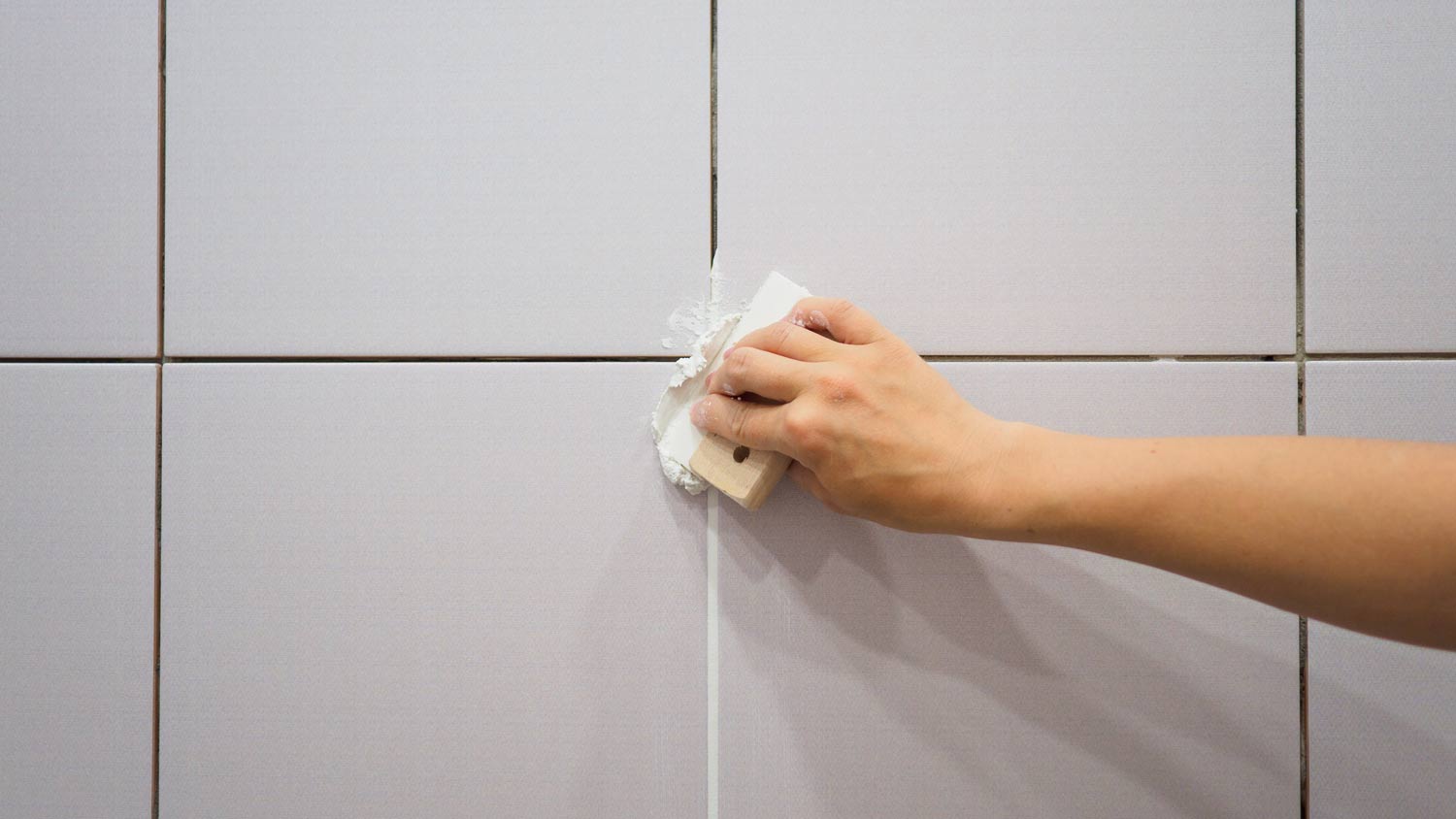 applying grout on wall tiles
