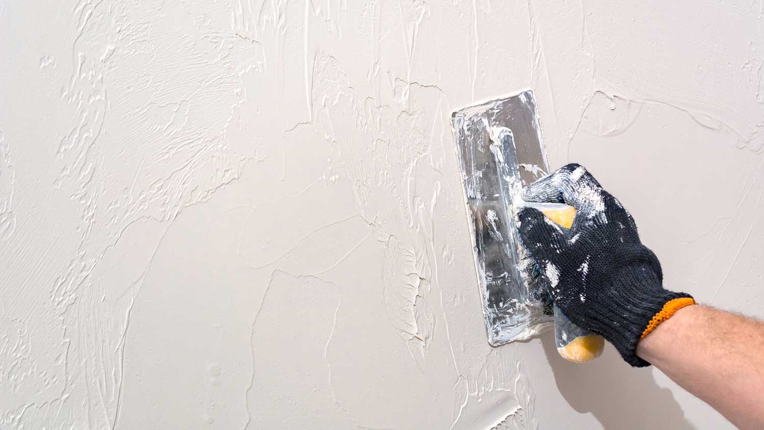 Closeup of a plasterer plastering a wall
