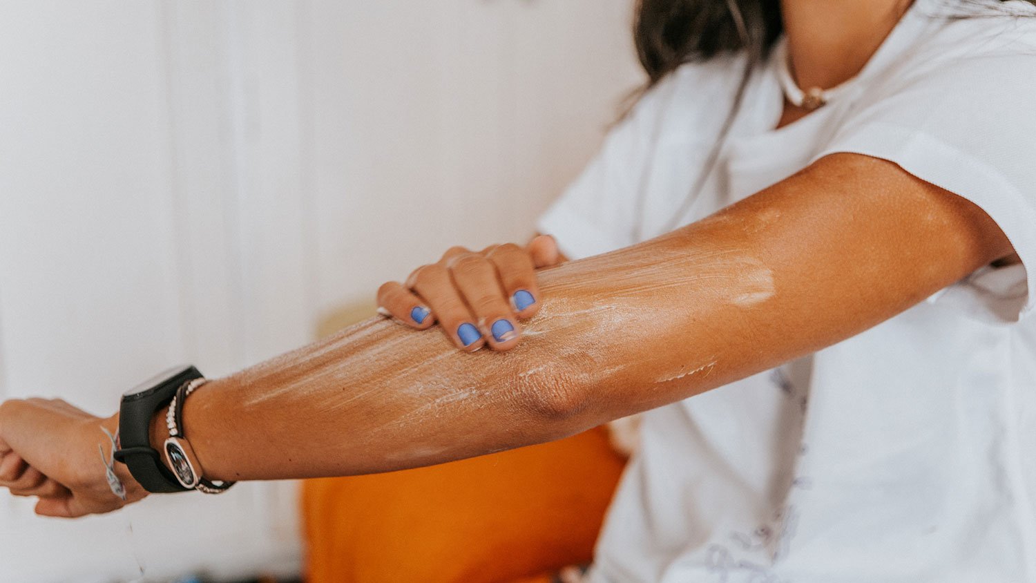 Closeup of a woman applying sunscreen on her arm