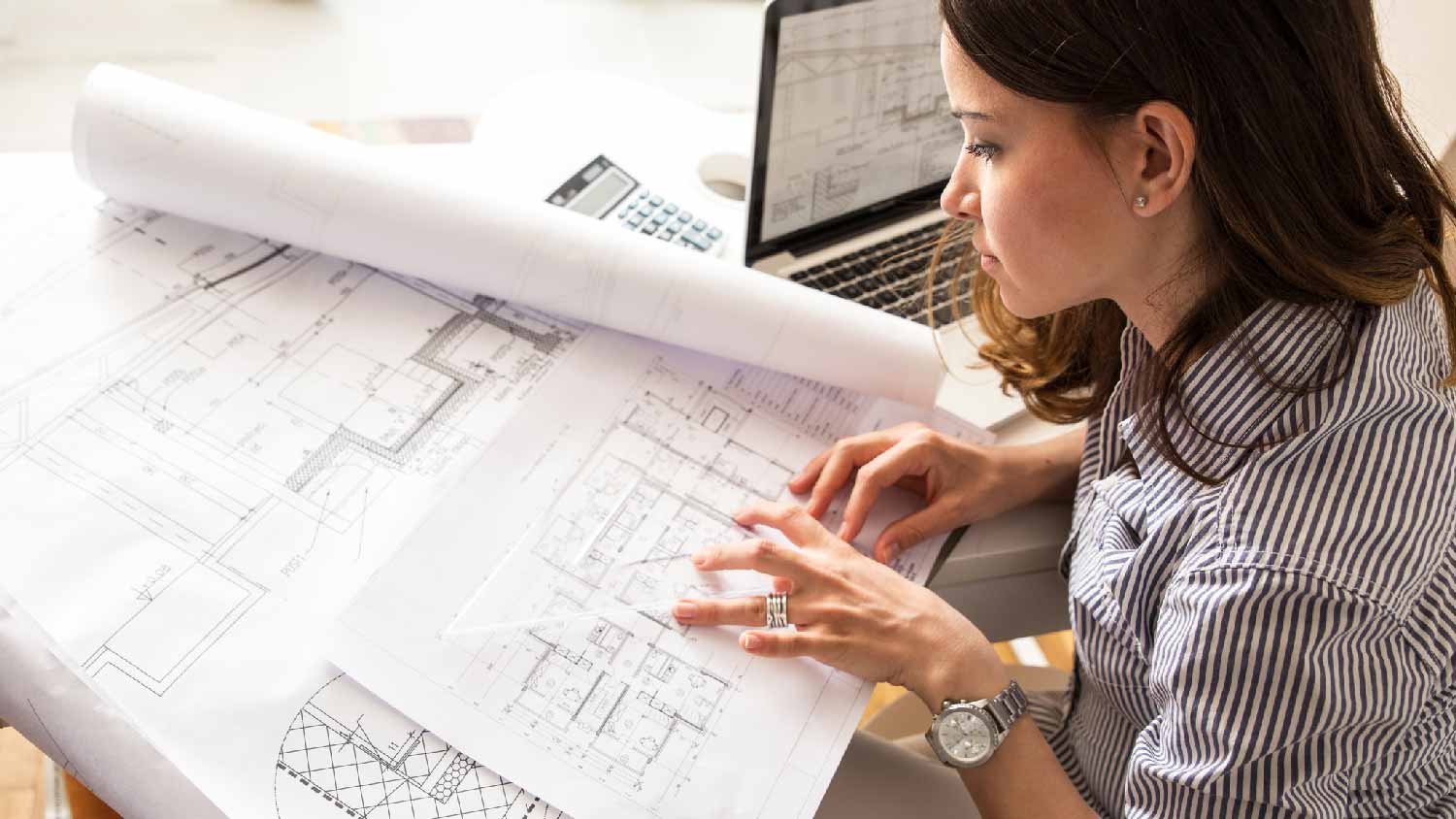 An architect looking at a house’s blueprints