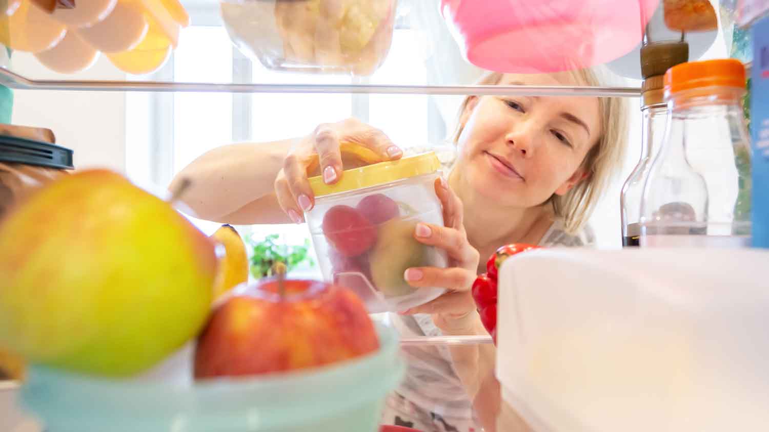 Woman arranging containers in the fridge