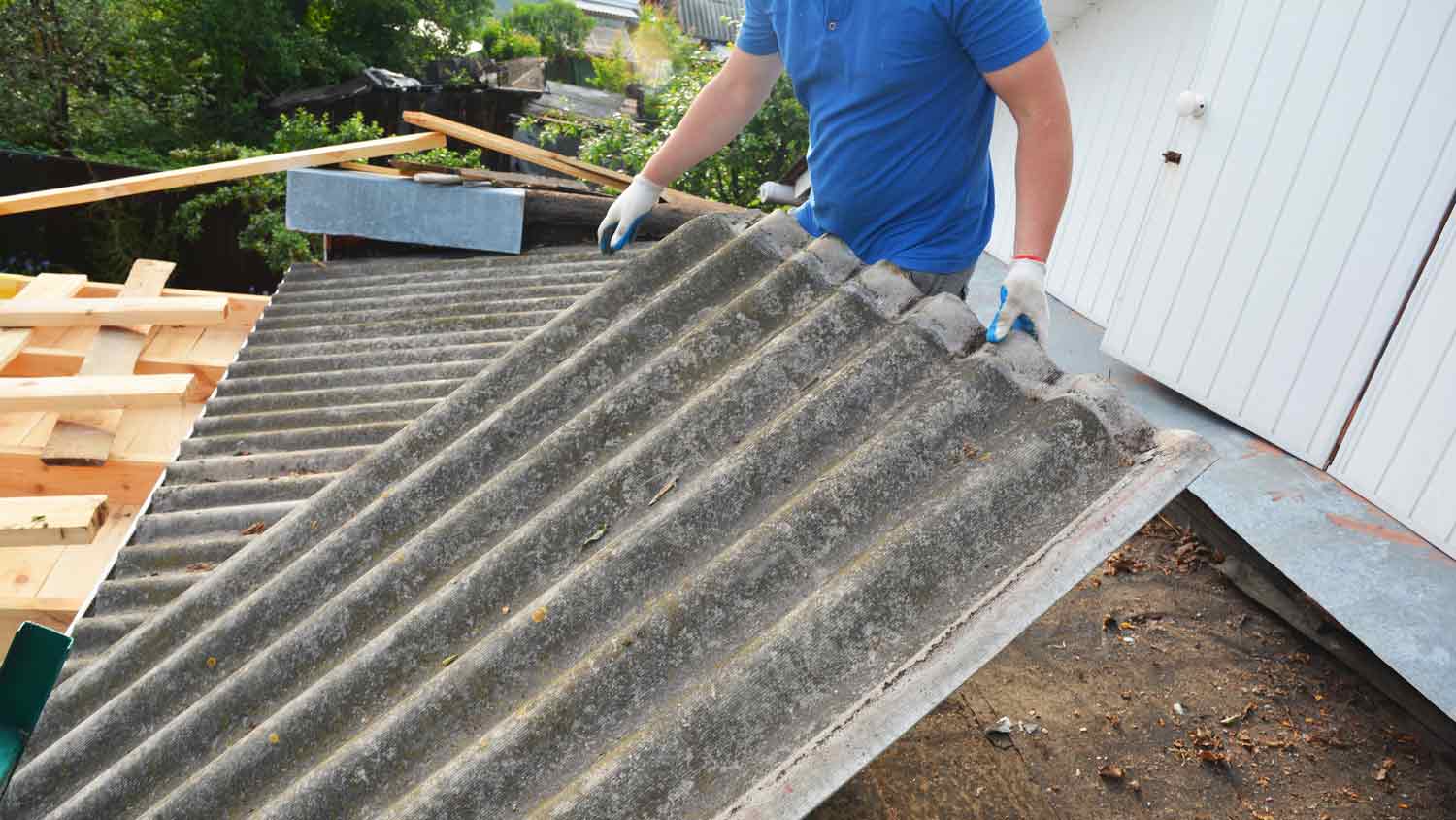 man removing roof with asbestos