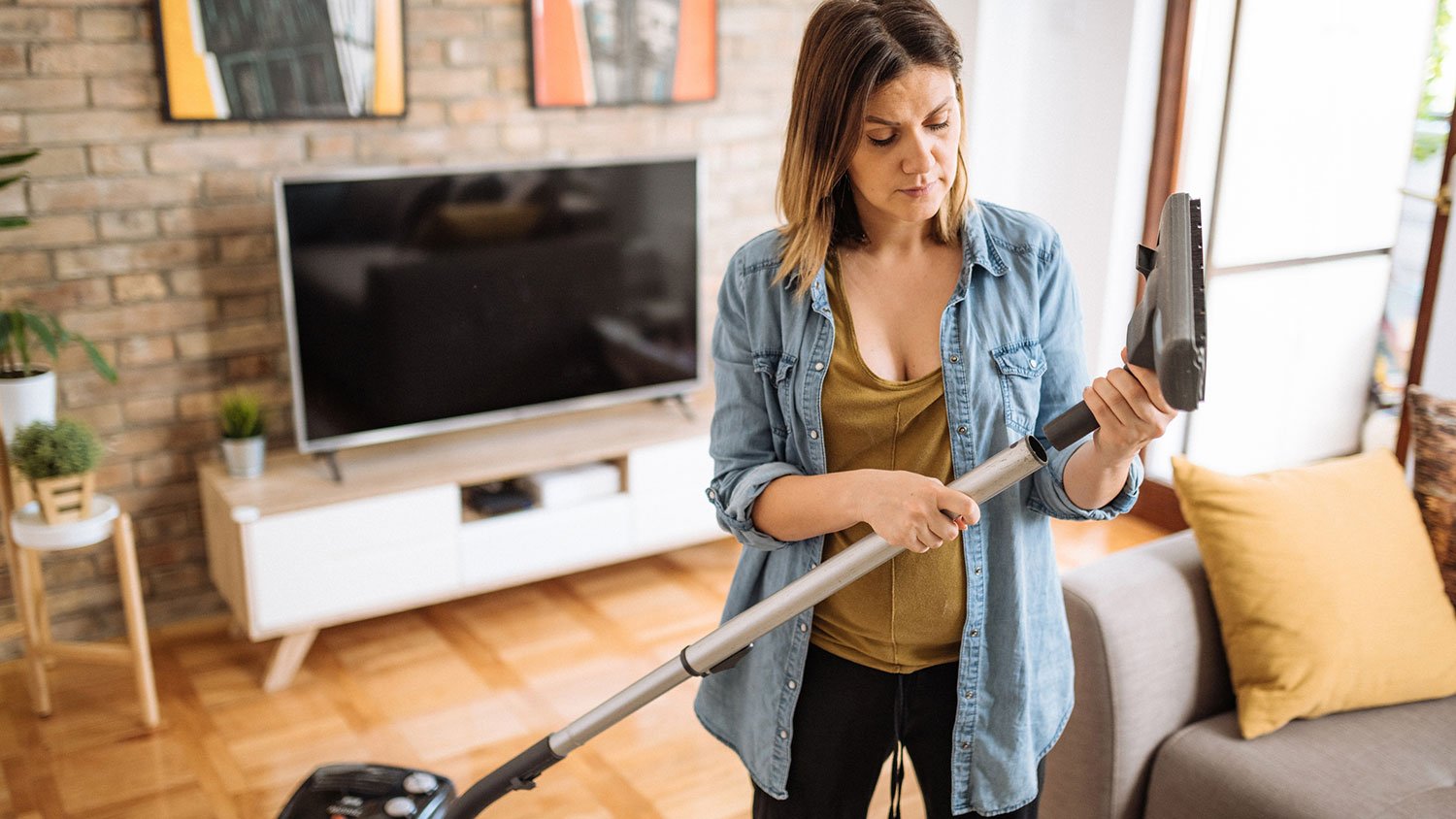 Woman attaching brush to the vacuum cleaner