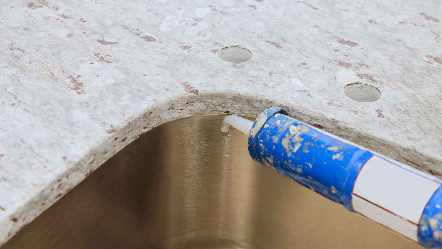 Using silicone adhesive to attach sink to a vanity