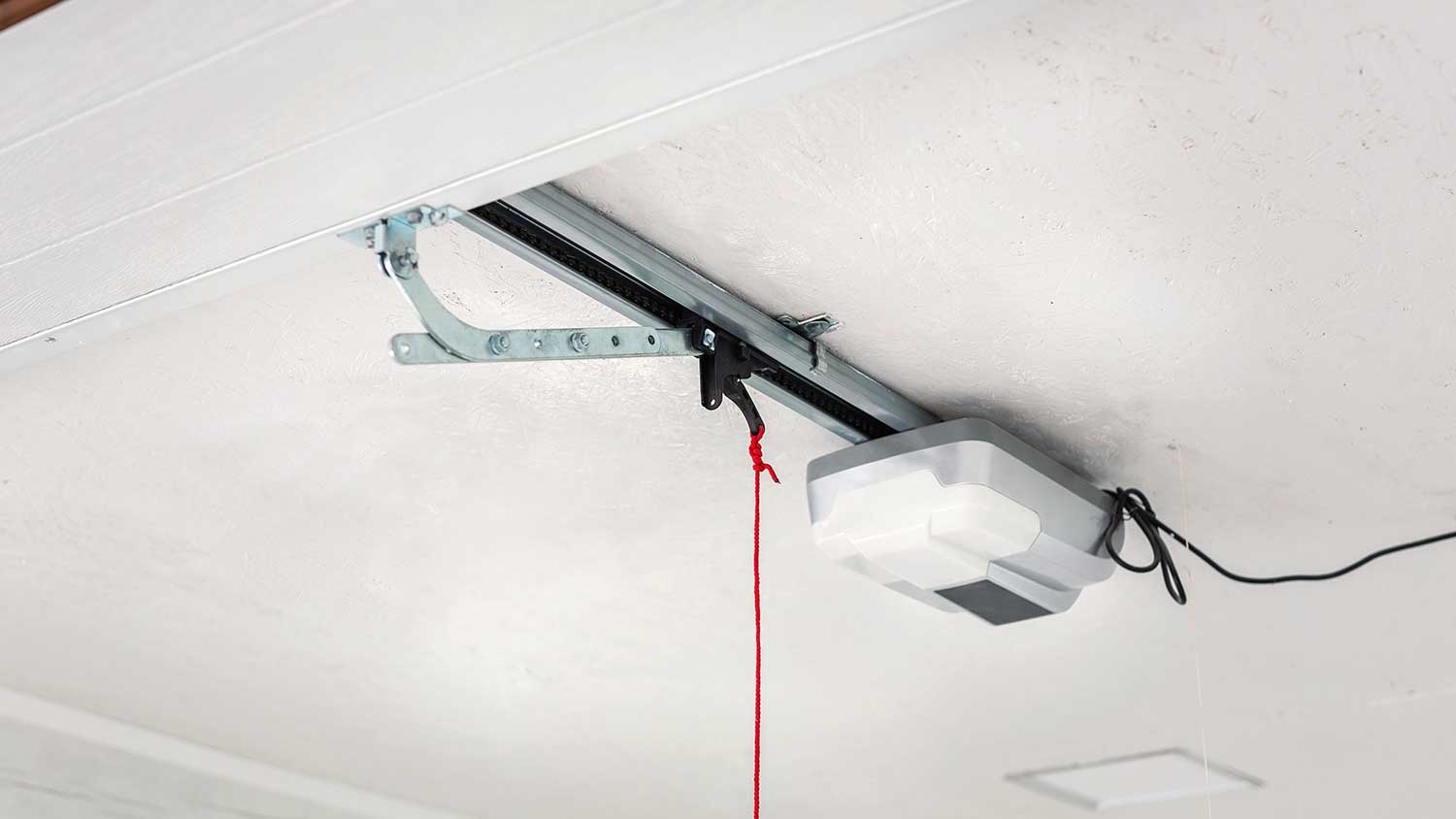 Automatic garage door opener mounted on a ceiling