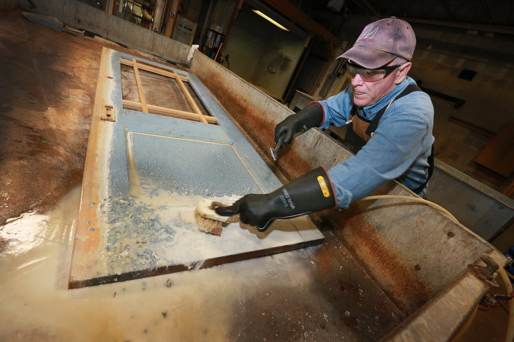 Greg Doublestein of The Front Gate in Indianapolis power-scrubs a door