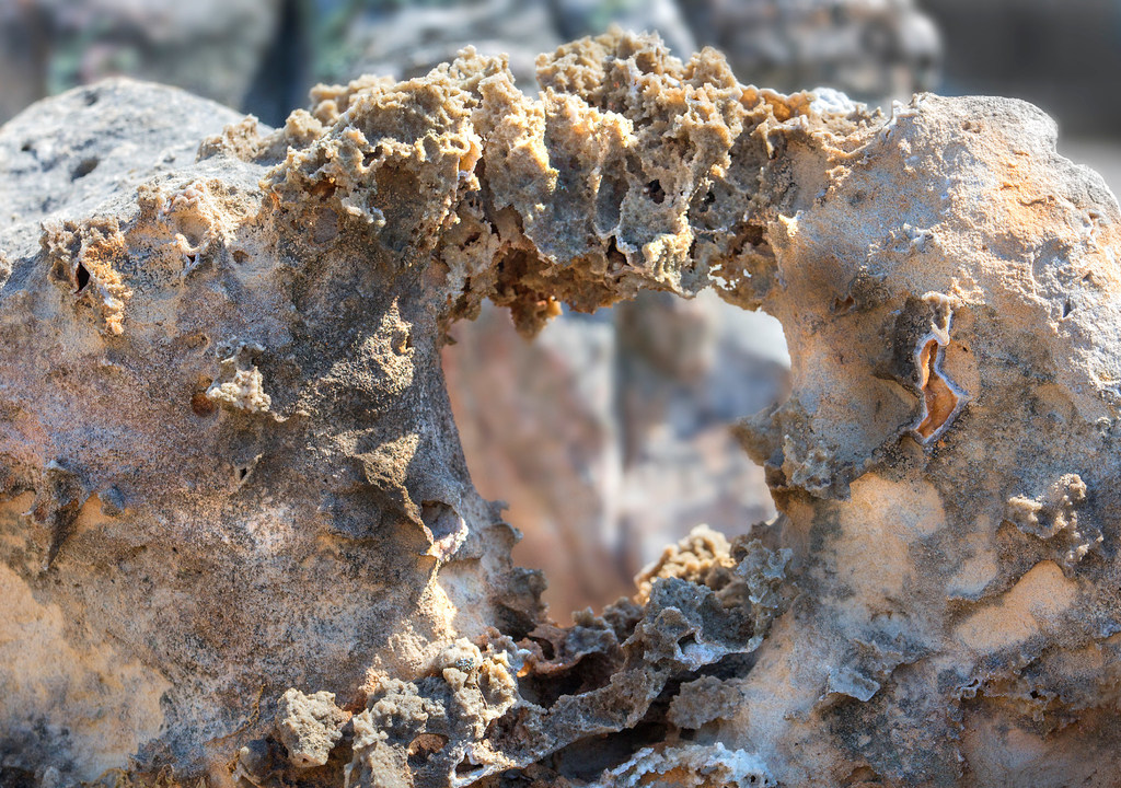 A large brownish rock with a natural opening