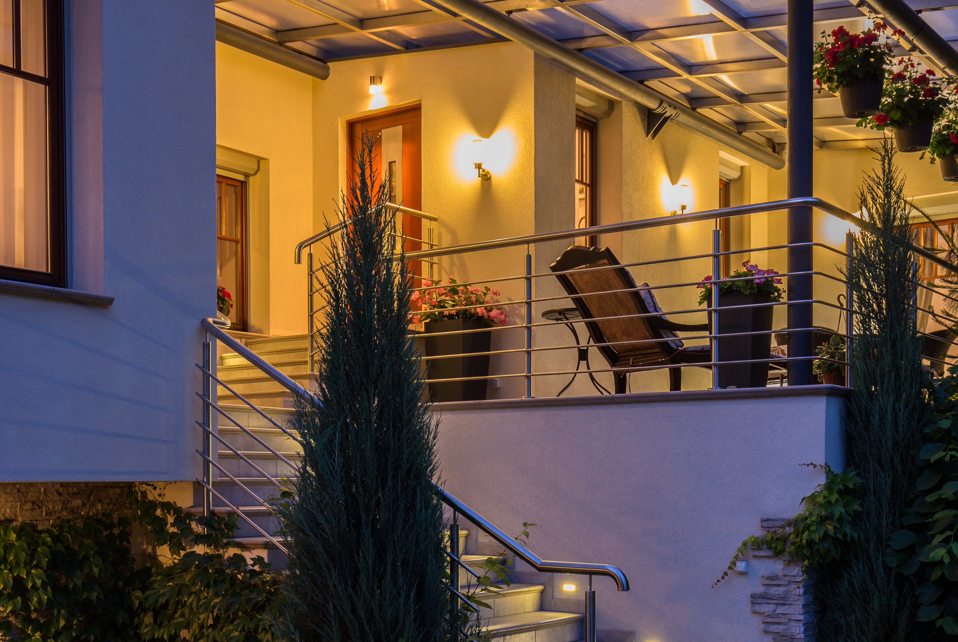 Contemporary home back porch with sconce lighting