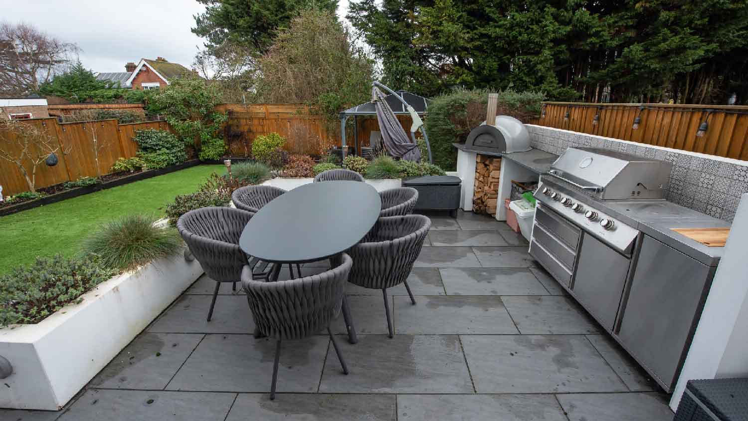 A backyard with artificial lawn and an outdoor kitchen