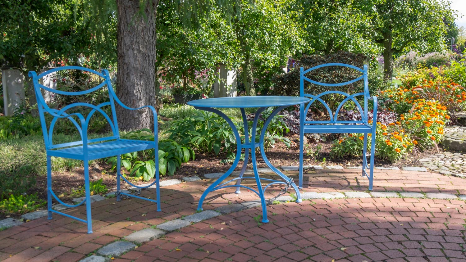 A backyard with a blue chairs and table 