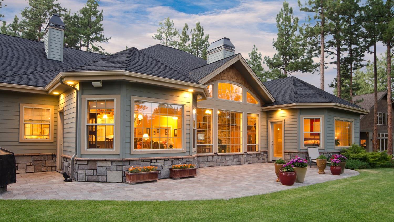 The backyard pavers patio of an illuminated house