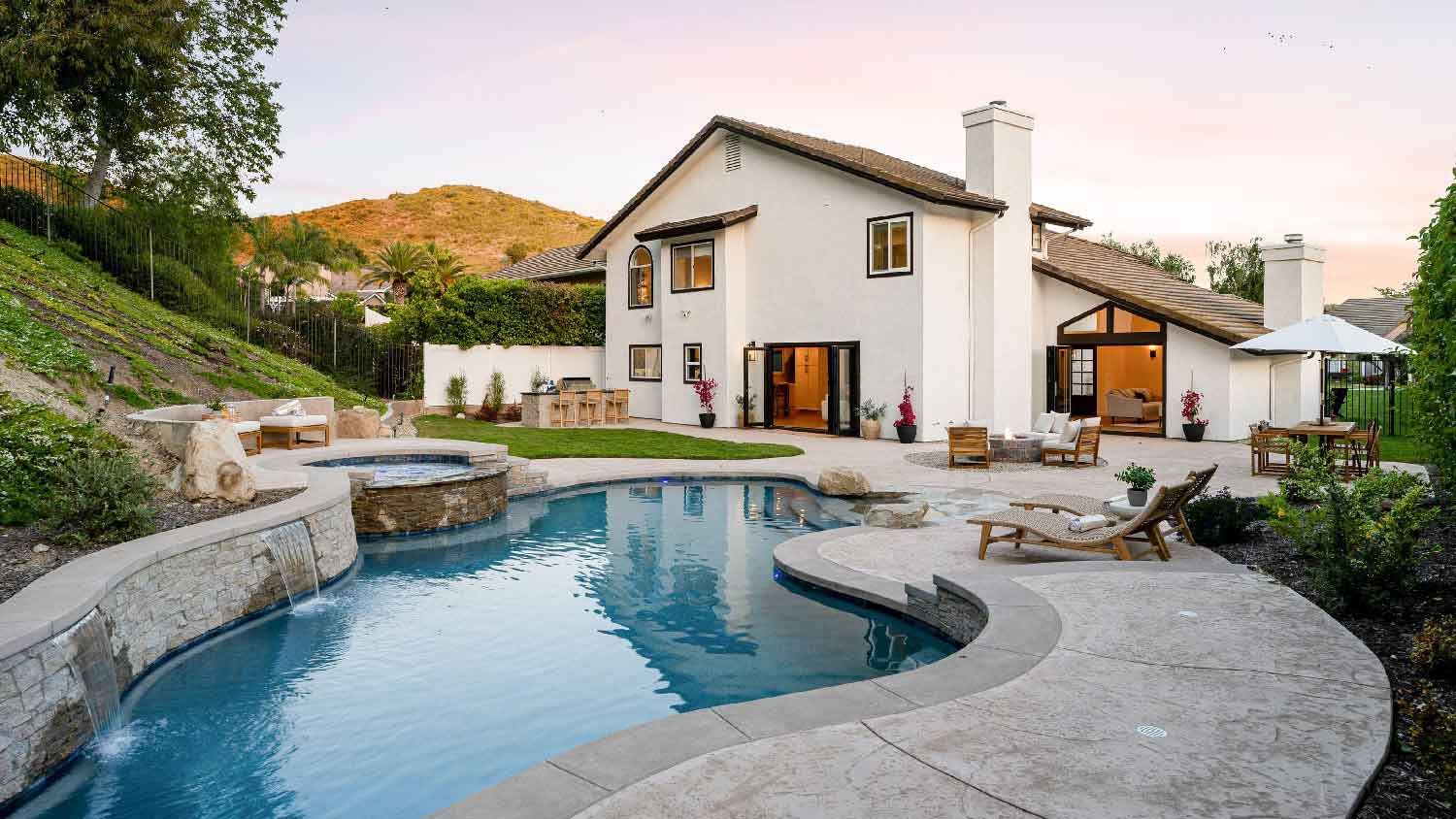A backyard with a swimming pool and a hot tub