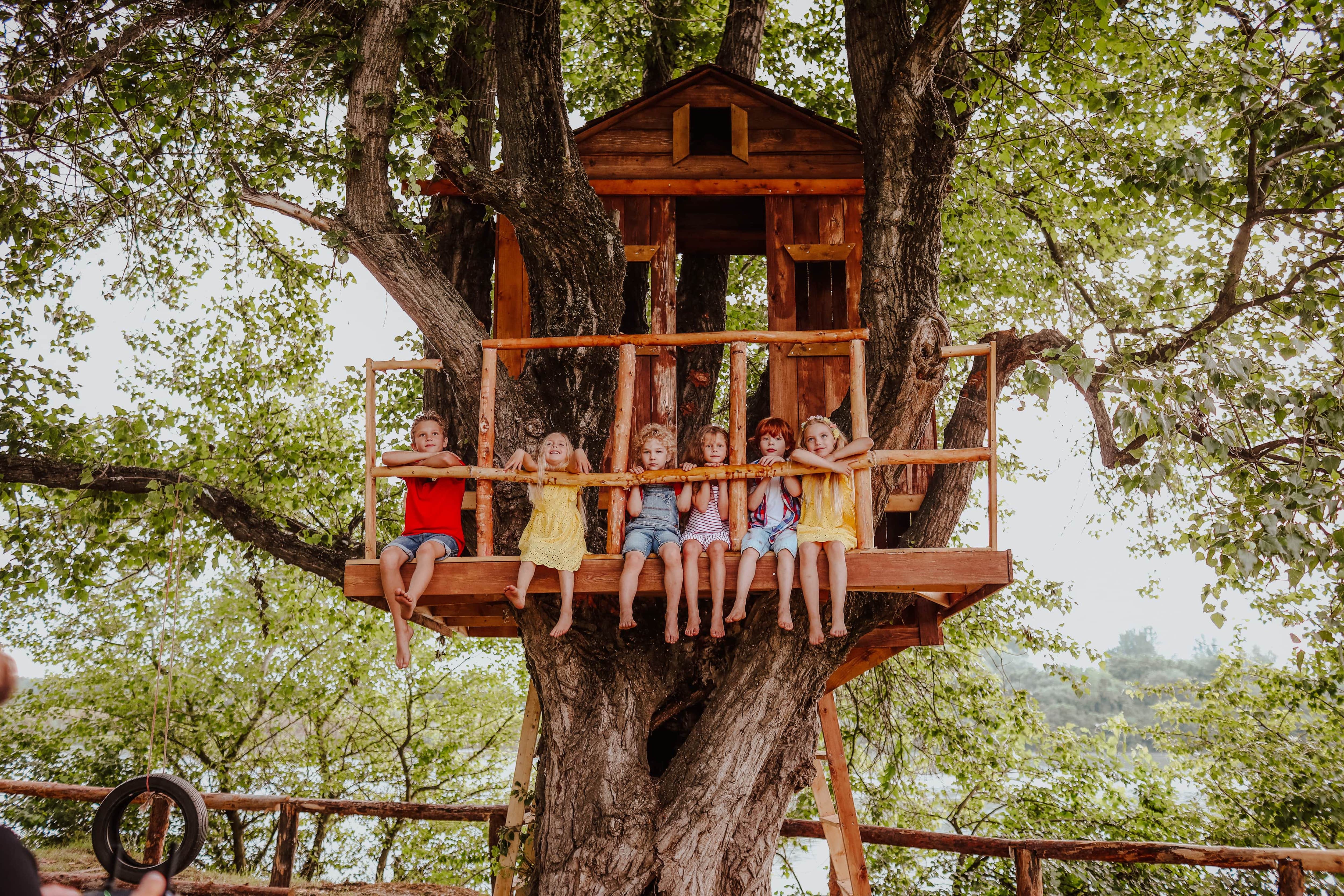 Kids playing in backyard treehouse