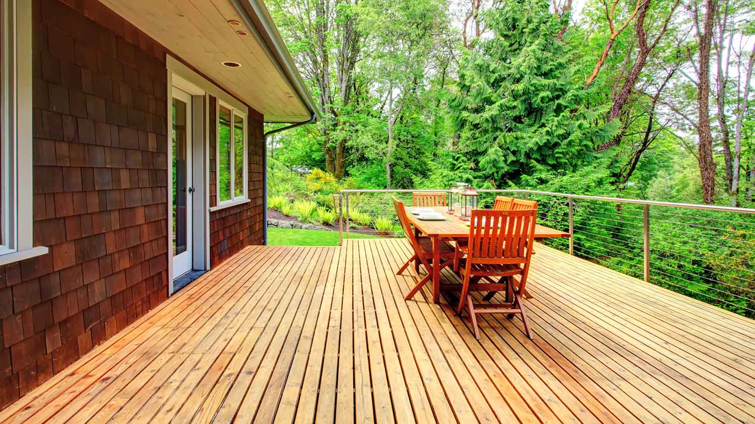 Wooden deck installed in a backyard surrounded by trees