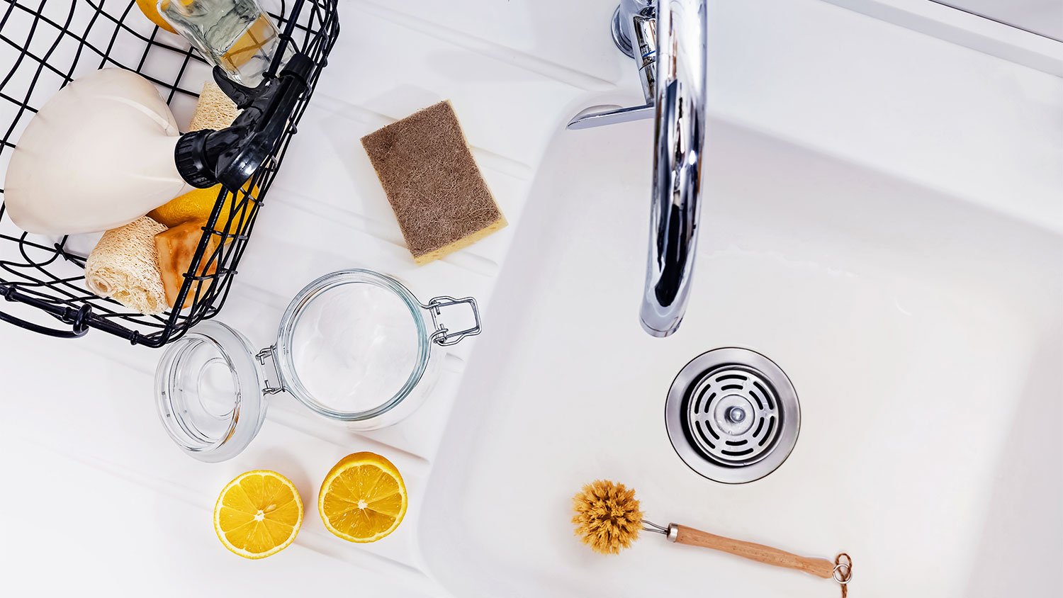 Baking soda and vinegar sit next to kitchen sink