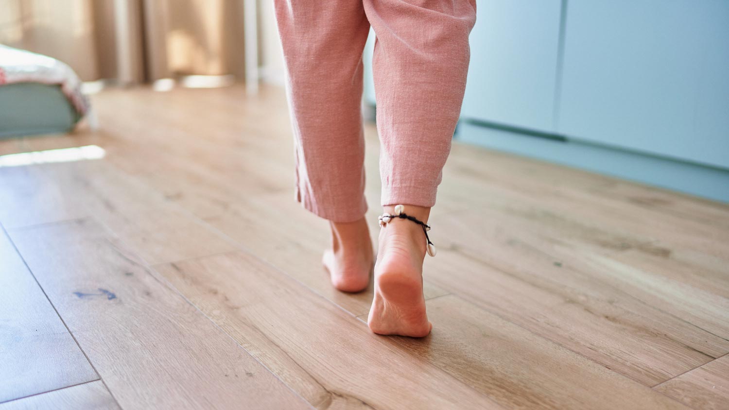 woman walking barefoot on hardwood floor