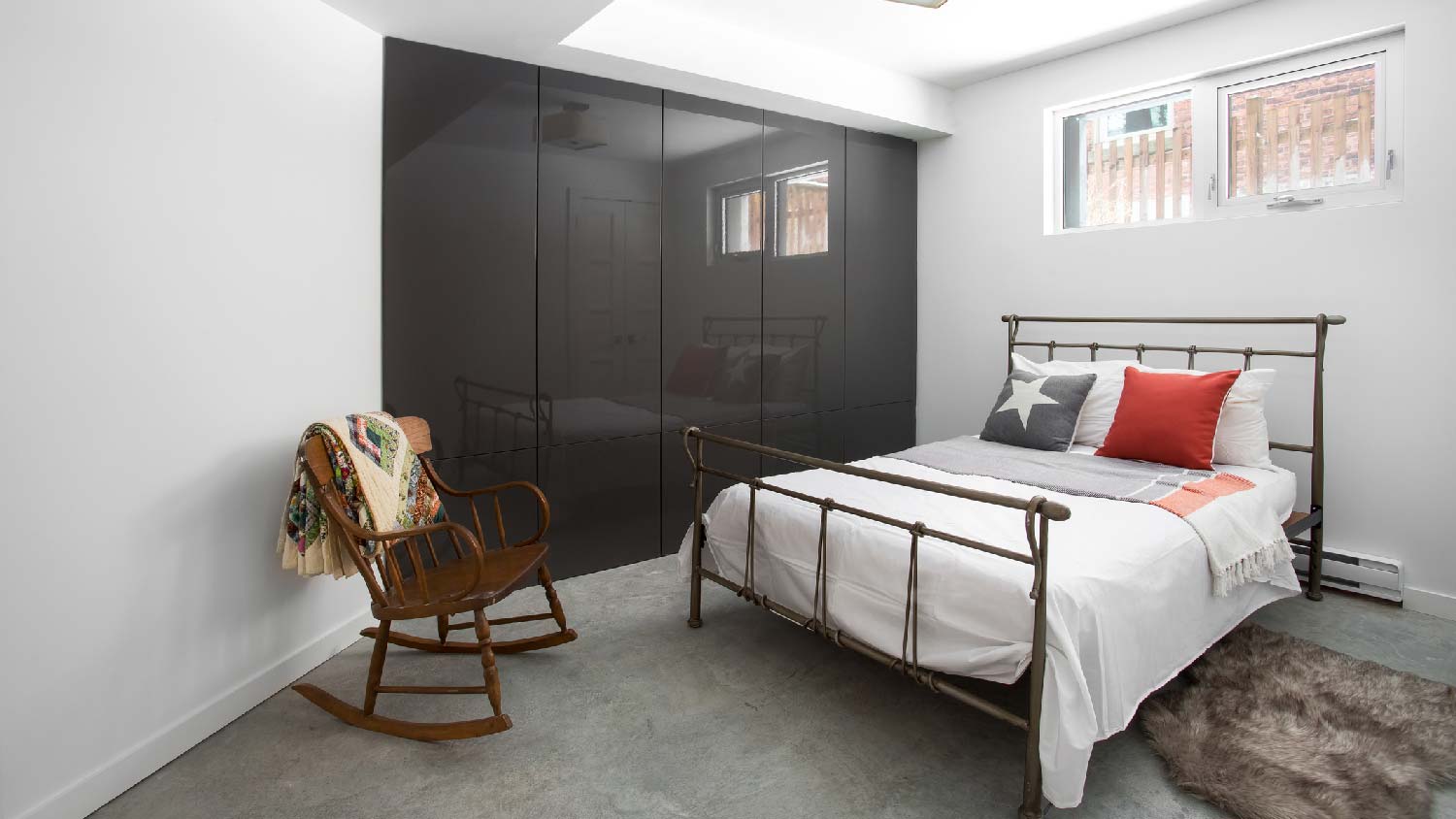 A basement bedroom with a rocking chair